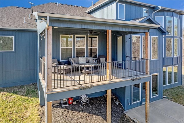 back of house featuring outdoor lounge area and roof with shingles