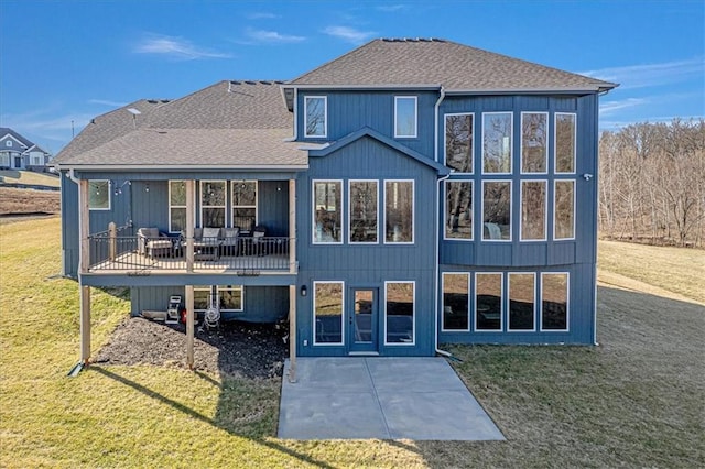 back of property featuring a yard, a patio area, a deck, and a shingled roof