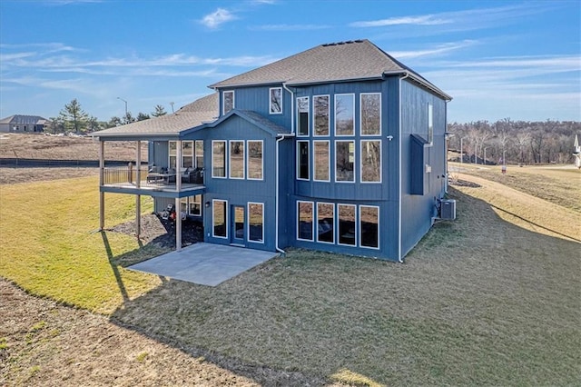 back of property featuring a patio, a lawn, central AC unit, and a shingled roof