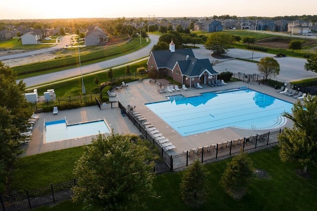 4500 NE 101st St, Kansas City, MO 64156 - pool at dusk with a residential view, a patio, a community pool, and fence