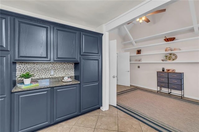 kitchen with light tile patterned floors, decorative backsplash, blue cabinetry, and a ceiling fan