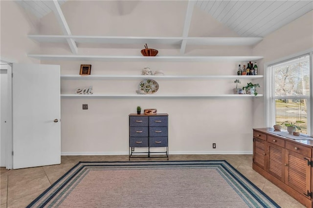 interior space featuring tile patterned flooring, lofted ceiling, and baseboards