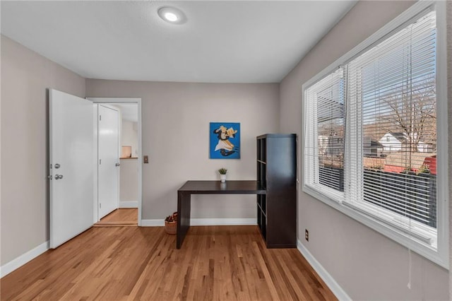 office space with light wood-style flooring and baseboards