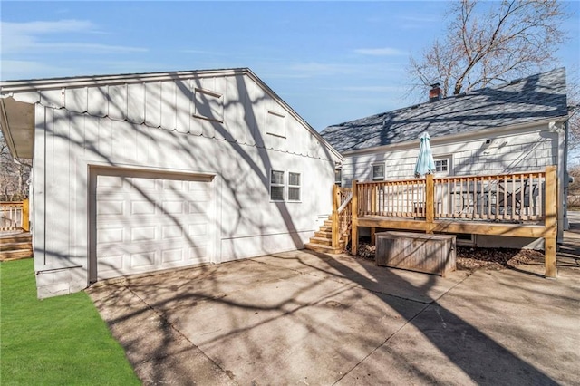 exterior space with a wooden deck, a chimney, and driveway