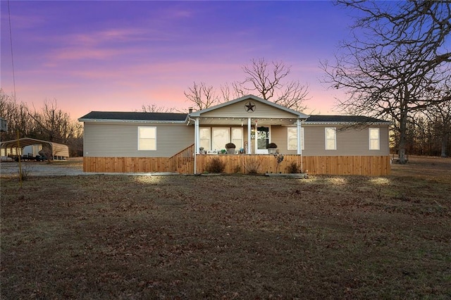 manufactured / mobile home with a detached carport and a porch