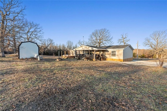 rear view of house with an outdoor structure and a shed