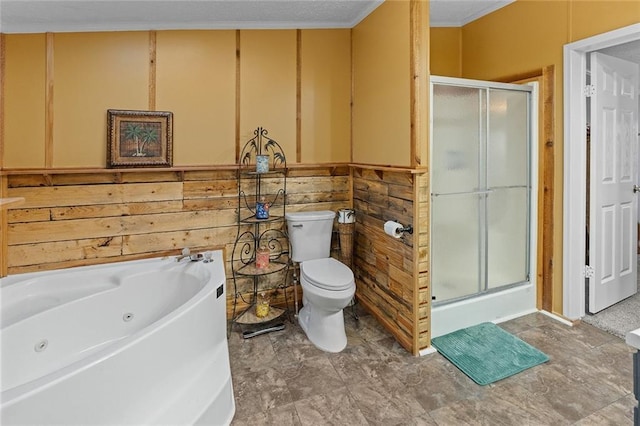 bathroom with toilet, a tub with jets, and a stall shower