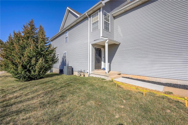 view of property exterior with a yard and central AC unit