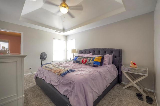 bedroom with visible vents, baseboards, carpet, and a tray ceiling