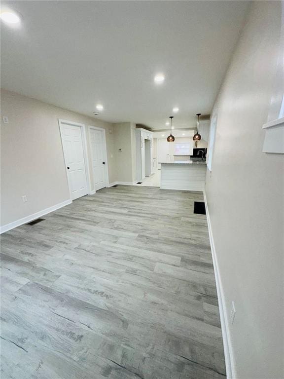 unfurnished living room featuring recessed lighting, visible vents, baseboards, and wood finished floors