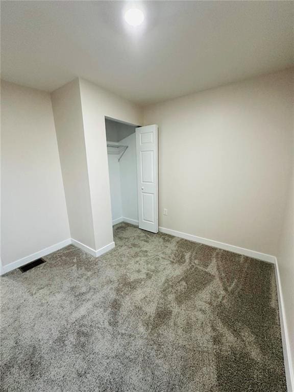 unfurnished bedroom featuring a closet, carpet, visible vents, and baseboards