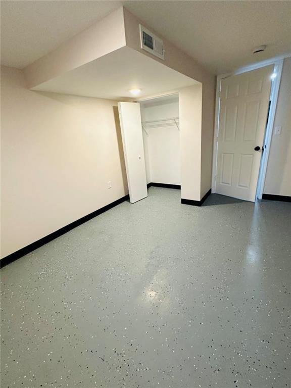 interior space featuring visible vents, baseboards, and light speckled floor