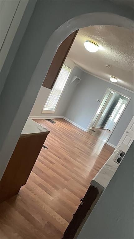 480 Wallace Ave, Kansas City, MO 64125 - additional living space featuring lofted ceiling, a textured ceiling, and wood finished floors