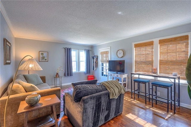 living area featuring a textured ceiling, crown molding, baseboards, and wood finished floors