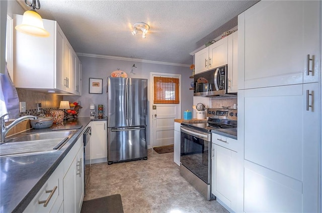 kitchen featuring a sink, stainless steel appliances, white cabinets, a textured ceiling, and dark countertops