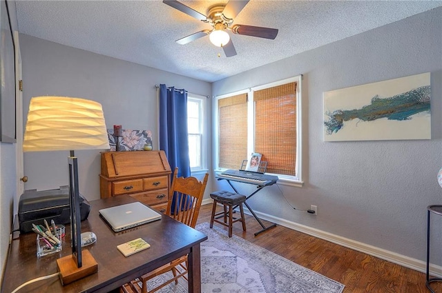 office space featuring a textured ceiling, wood finished floors, baseboards, ceiling fan, and a textured wall