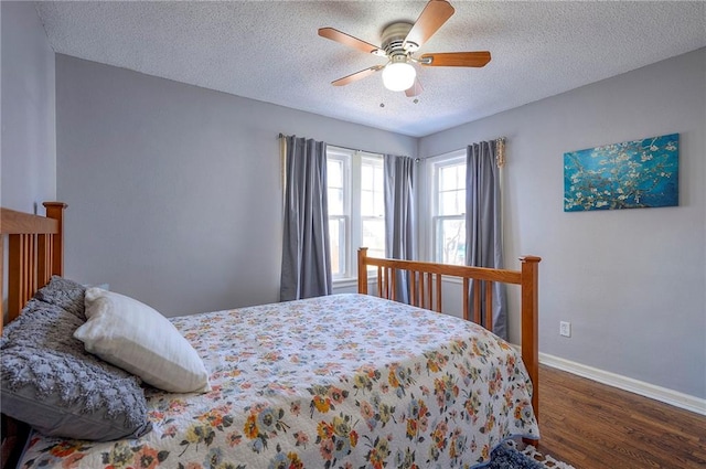 bedroom with ceiling fan, a textured ceiling, baseboards, and wood finished floors