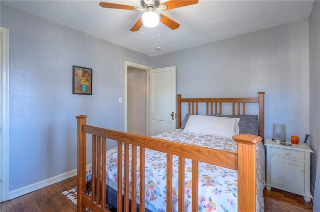 bedroom with ceiling fan, baseboards, dark wood-style flooring, and a textured ceiling