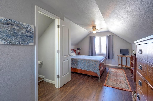 bedroom featuring lofted ceiling, a textured ceiling, wood finished floors, baseboards, and ceiling fan