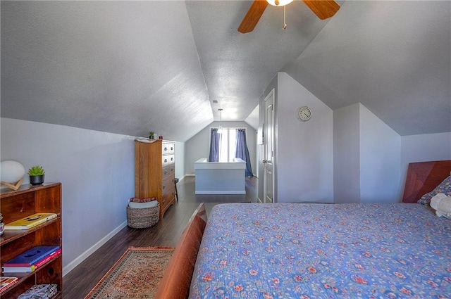 bedroom featuring baseboards, lofted ceiling, wood finished floors, a textured ceiling, and a ceiling fan