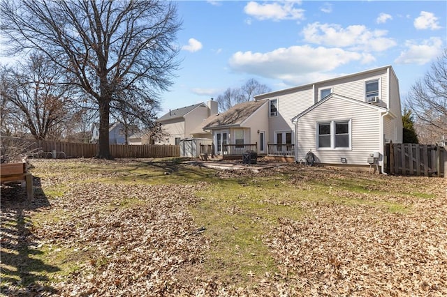 rear view of property featuring fence and a wooden deck