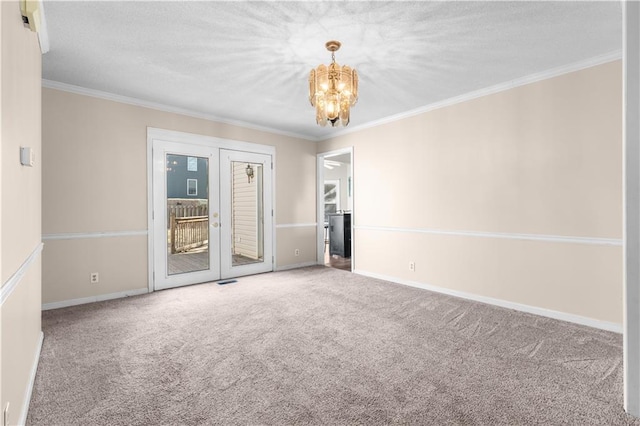 empty room featuring baseboards, ornamental molding, carpet floors, french doors, and a notable chandelier