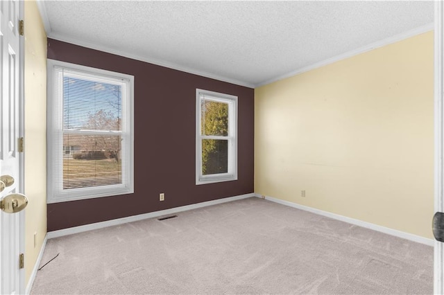 unfurnished room with baseboards, carpet, ornamental molding, and a textured ceiling