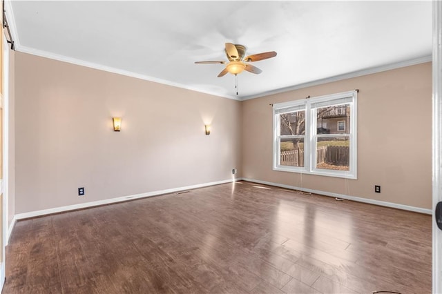 empty room with crown molding, wood finished floors, baseboards, and ceiling fan