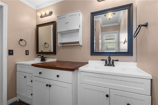 bathroom featuring a sink, two vanities, and ornamental molding