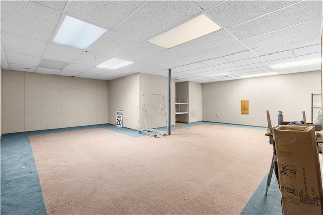 finished below grade area featuring a drop ceiling and carpet flooring