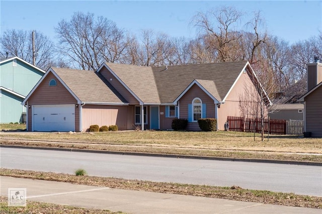 ranch-style home featuring driveway, an attached garage, a front yard, and fence