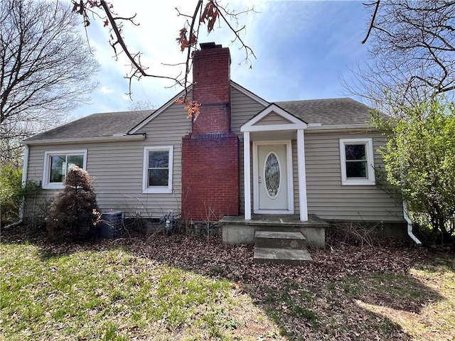 5200 NW Valley View Rd, Blue Springs, MO 64015 - view of front of home with a chimney, roof with shingles, and central AC