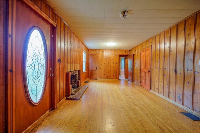 5200 NW Valley View Rd, Blue Springs, MO 64015 - entryway featuring light wood-type flooring, healthy amount of natural light, wooden walls, baseboards, and a fireplace with raised hearth