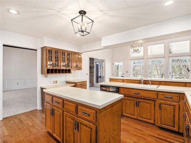 kitchen featuring brown cabinetry, a notable chandelier, a center island, and a wealth of natural light