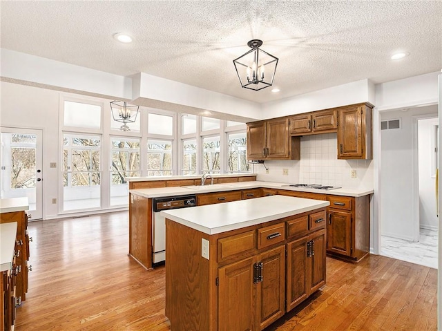 kitchen featuring white appliances, light countertops, visible vents, and a wealth of natural light