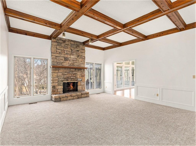 unfurnished living room featuring beamed ceiling, a fireplace, coffered ceiling, and carpet floors