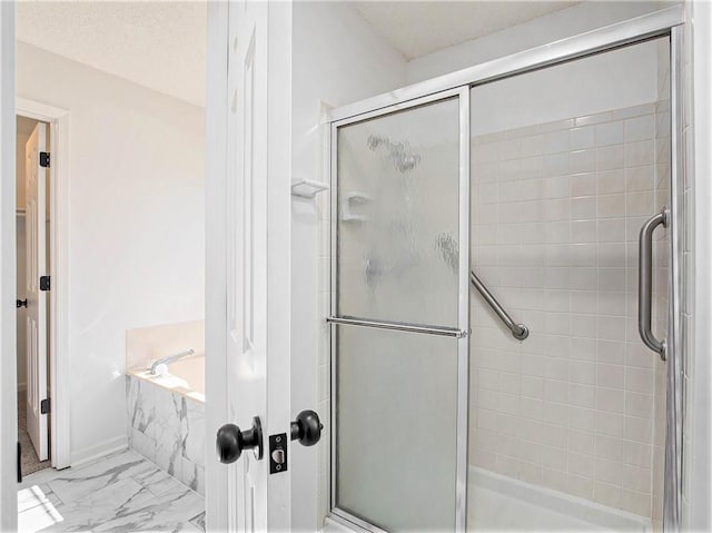 bathroom featuring a shower stall, a garden tub, marble finish floor, and a textured ceiling