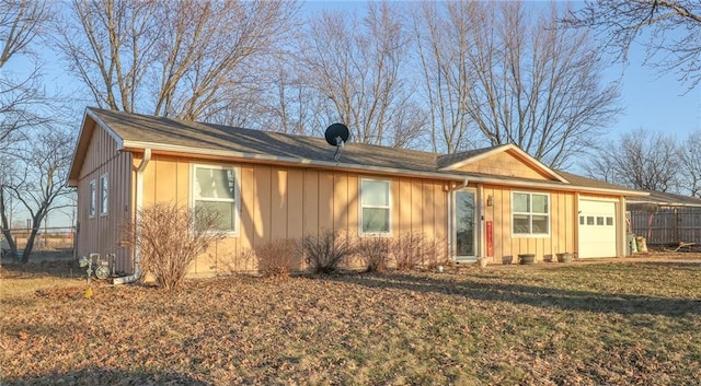 single story home featuring a front lawn, board and batten siding, an attached garage, and fence