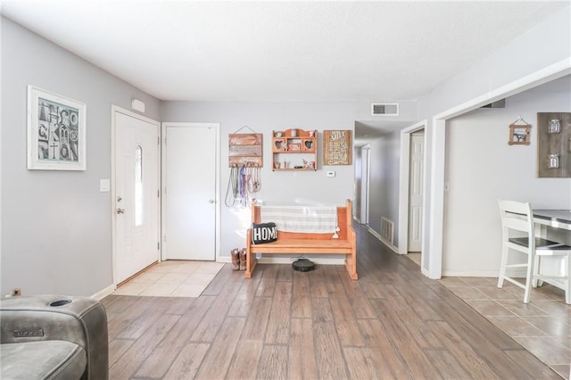 foyer featuring visible vents, light wood-style flooring, and baseboards