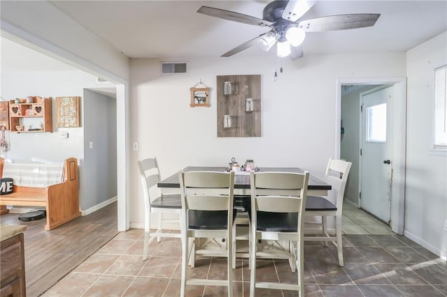 tiled dining space with a ceiling fan, visible vents, and baseboards