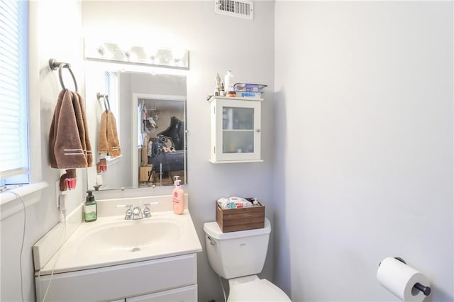 bathroom featuring visible vents, vanity, and toilet