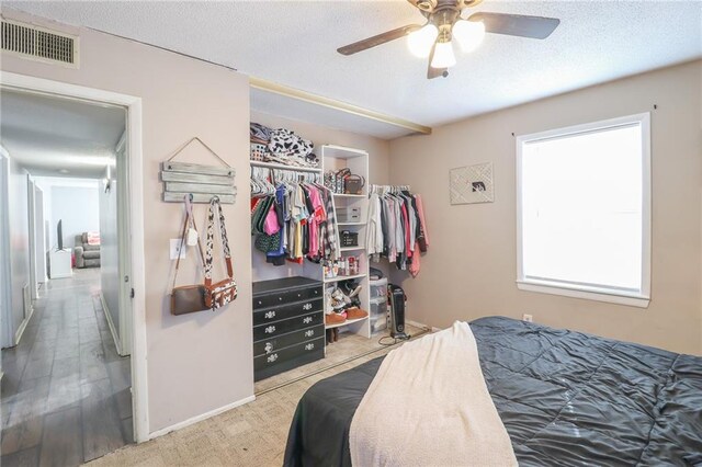 bedroom featuring a textured ceiling, ceiling fan, a closet, and visible vents