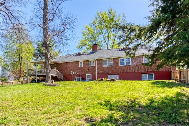 rear view of property featuring fence, a chimney, stairs, central air condition unit, and a lawn