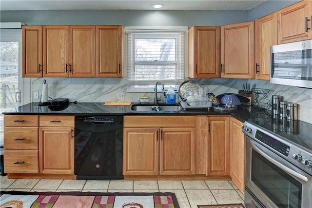 kitchen featuring dark countertops, tasteful backsplash, appliances with stainless steel finishes, light tile patterned flooring, and a sink