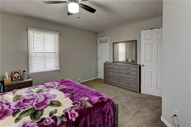 carpeted bedroom with a ceiling fan, baseboards, and a textured ceiling