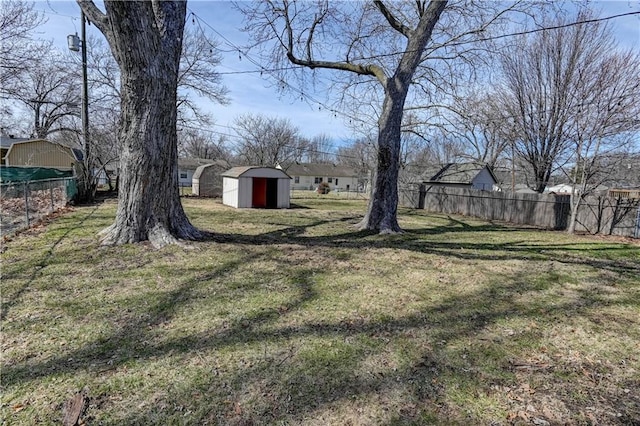 view of yard featuring a shed, an outdoor structure, and fence