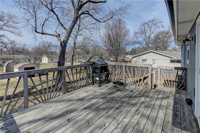 deck featuring grilling area, an outbuilding, and a storage shed