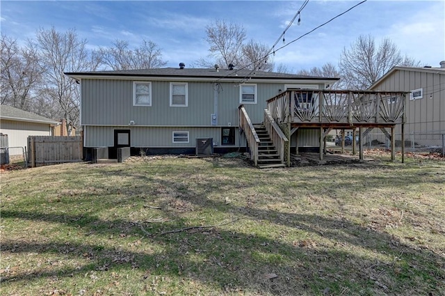 back of property with fence, a wooden deck, stairs, central AC unit, and a yard