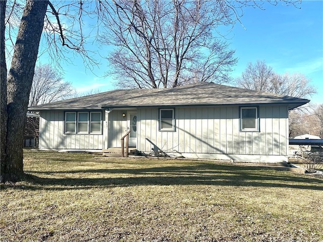 view of front facade with board and batten siding and a front yard