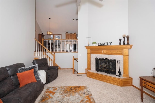 carpeted living room featuring stairway, a ceiling fan, lofted ceiling, and baseboards